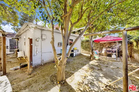 a backyard of a house with barbeque oven table and chairs