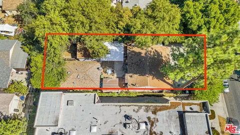 an aerial view of a house with a yard and trees