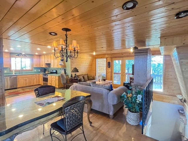 2498 West Silverado Ridge Alton, UT 84710 - Photo 7 of 51 Dining room with wooden walls, a chandelier, light wood-style floors, french doors, and wood ceiling