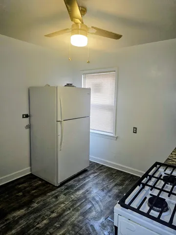 a kitchen with a refrigerator and a stove top oven
