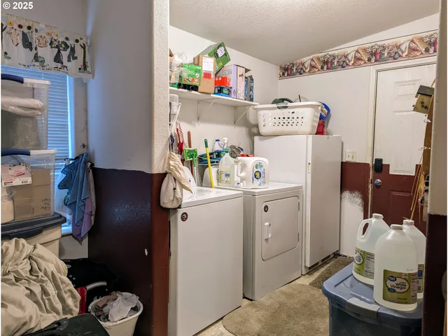 a utility room with fridge dryer and washer