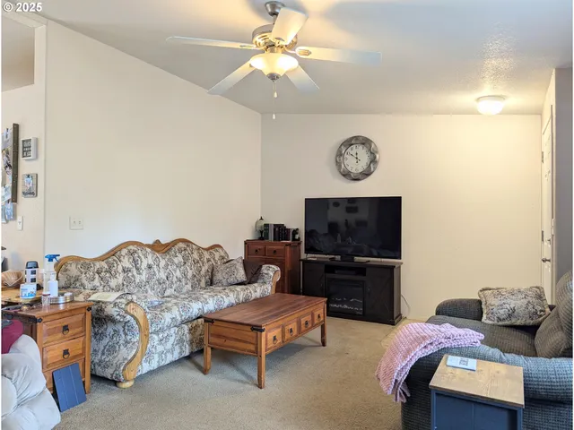 a living room with furniture a flat screen tv and a wall painting