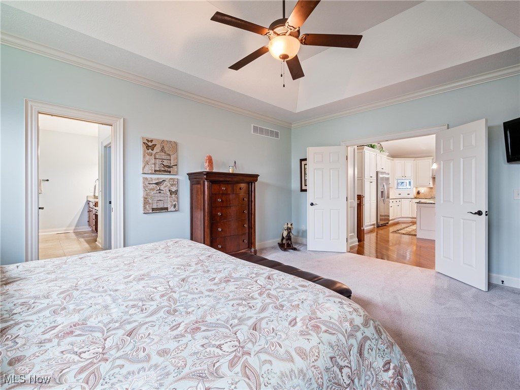 5349 Slater Ridge Westerville, OH 43082 - Photo 25 of 50 Bedroom with ornamental molding, a raised ceiling, light colored carpet, ceiling fan, and stainless steel refrigerator with ice dispenser