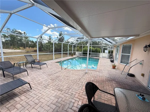 a view of a patio with a dining table and chairs with wooden floor