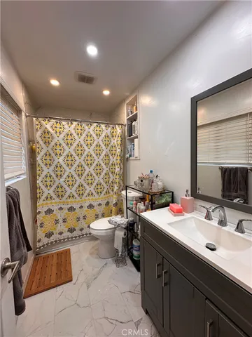 a bathroom with a sink toilet double vanity and shower