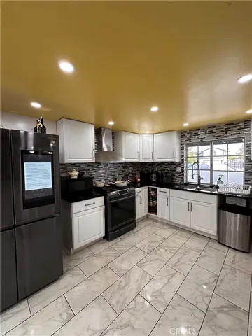 a large kitchen with a stove a sink a microwave and cabinets