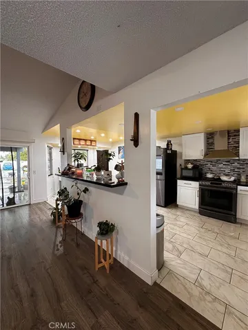 a kitchen with stainless steel appliances kitchen island granite countertop a stove and a view of living room