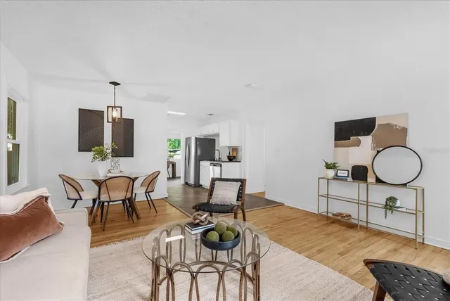 a living room with furniture a dining table and a chandelier
