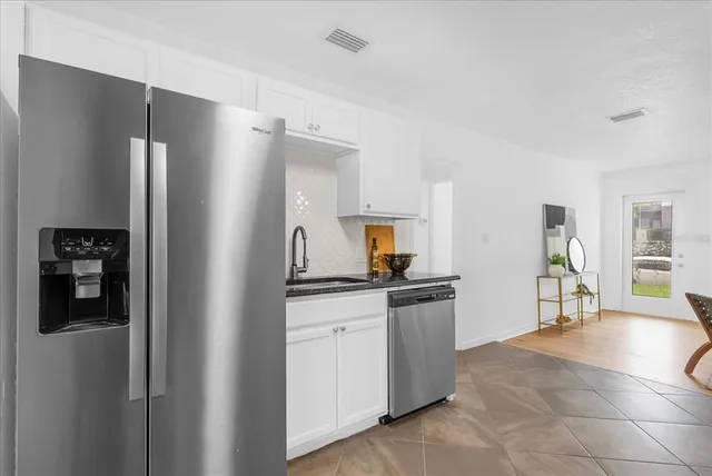a kitchen with stainless steel appliances granite countertop a refrigerator and a stove