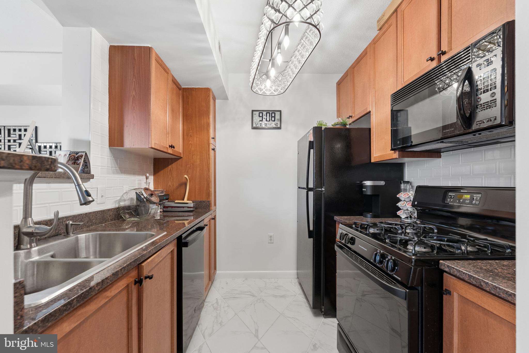 851 North Glebe Road, Unit 706 Arlington, VA 22203 - Photo 13 of 34 a kitchen with stainless steel appliances granite countertop a sink stove and refrigerator