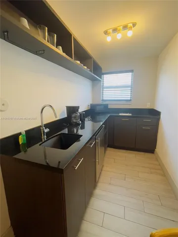 a kitchen with granite countertop a sink and cabinets