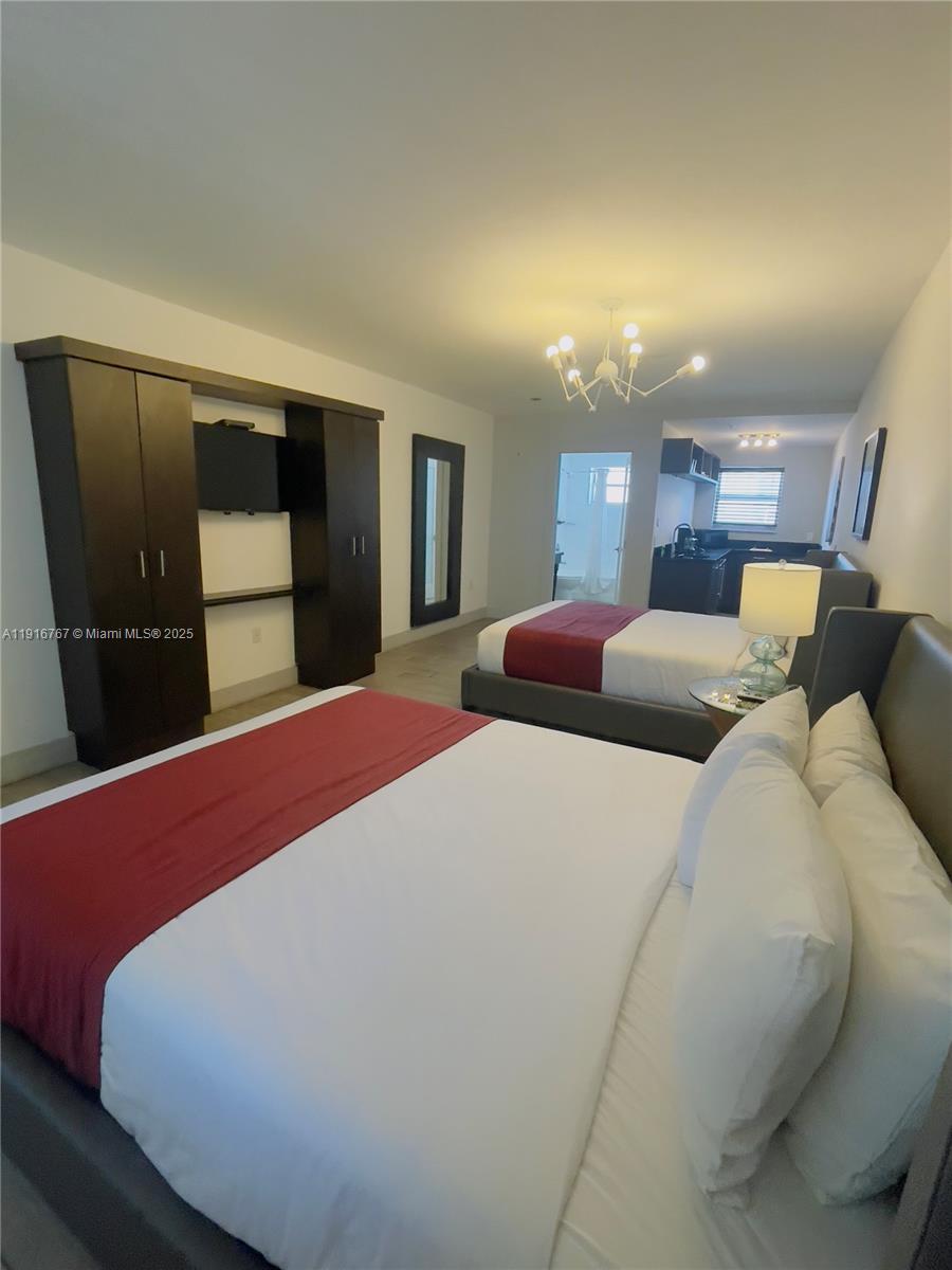 7500 Collins Avenue, Unit 112 Miami Beach, FL 33141 - Photo 3 of 10 a bed room with a bed and mirror