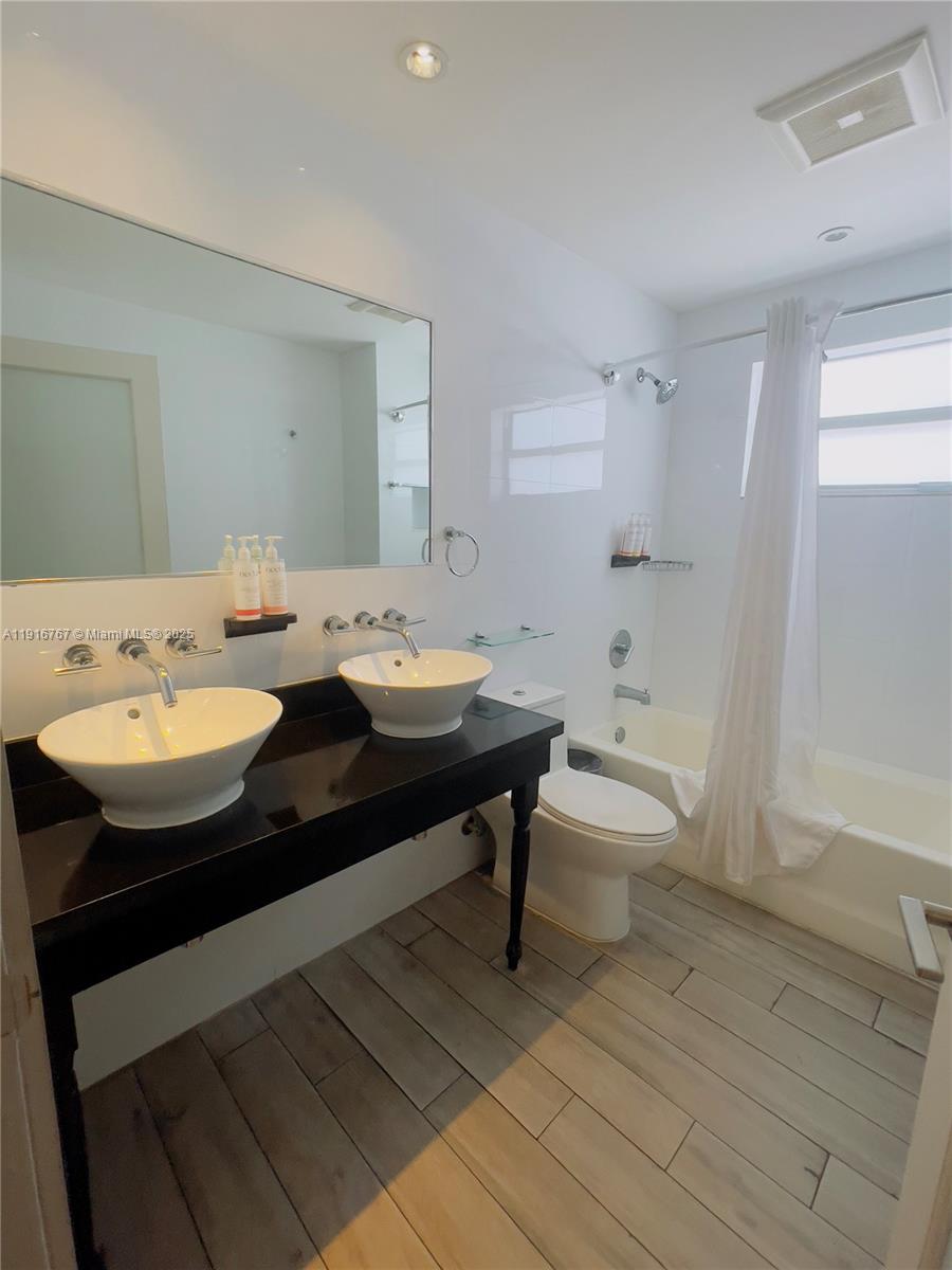 7500 Collins Avenue, Unit 112 Miami Beach, FL 33141 - Photo 5 of 10 a bathroom with a sink and a mirror