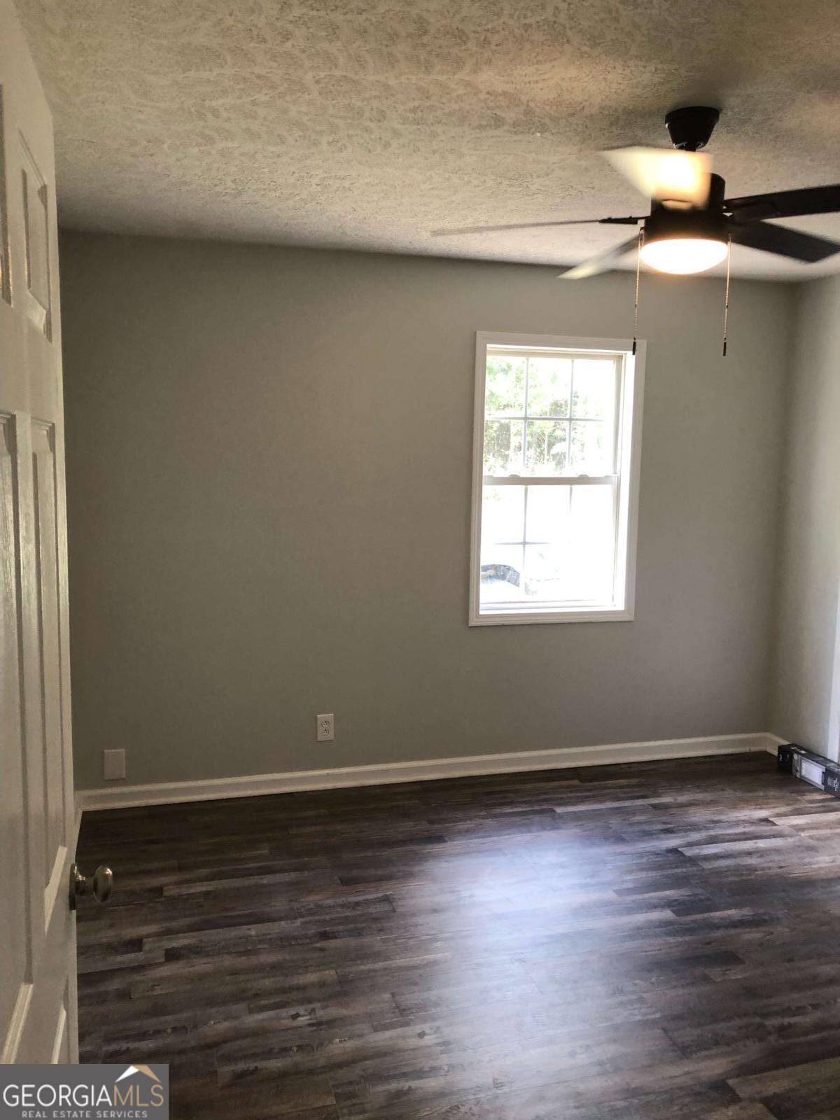153 A Cox Road Gordon, GA 31031 - Photo 13 of 16 an empty room with wooden floor and windows