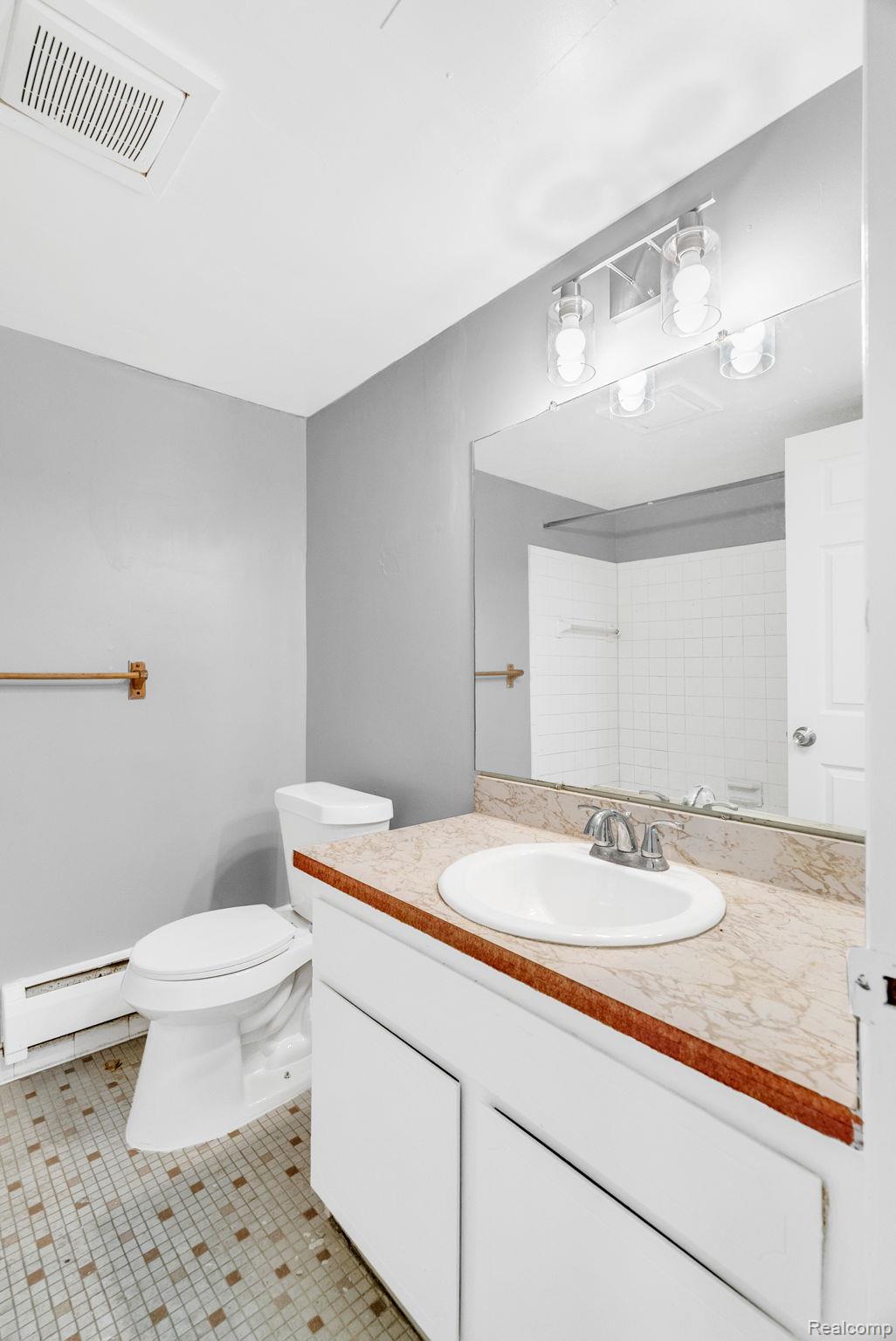 4535 Cadieux Road, Unit 42 / 210 Detroit, MI 48224 - Photo 15 of 16 Bathroom featuring vanity, a baseboard radiator, light tile patterned floors, and a shower