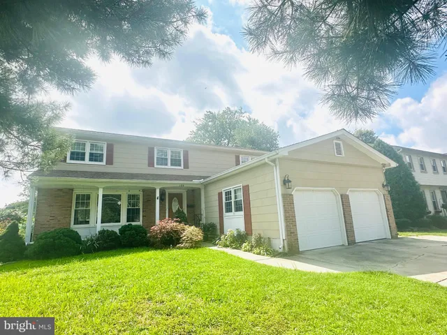 a front view of a house with a garden and yard