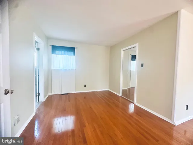 a view of a room with wooden floor and a window