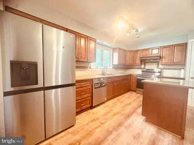a kitchen with stainless steel appliances granite countertop a refrigerator sink and cabinets