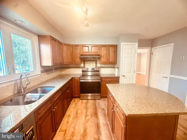 a kitchen with stainless steel appliances granite countertop a sink stove and cabinets