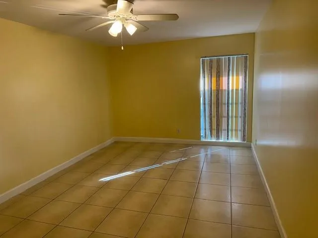 an empty room with fan and entrance