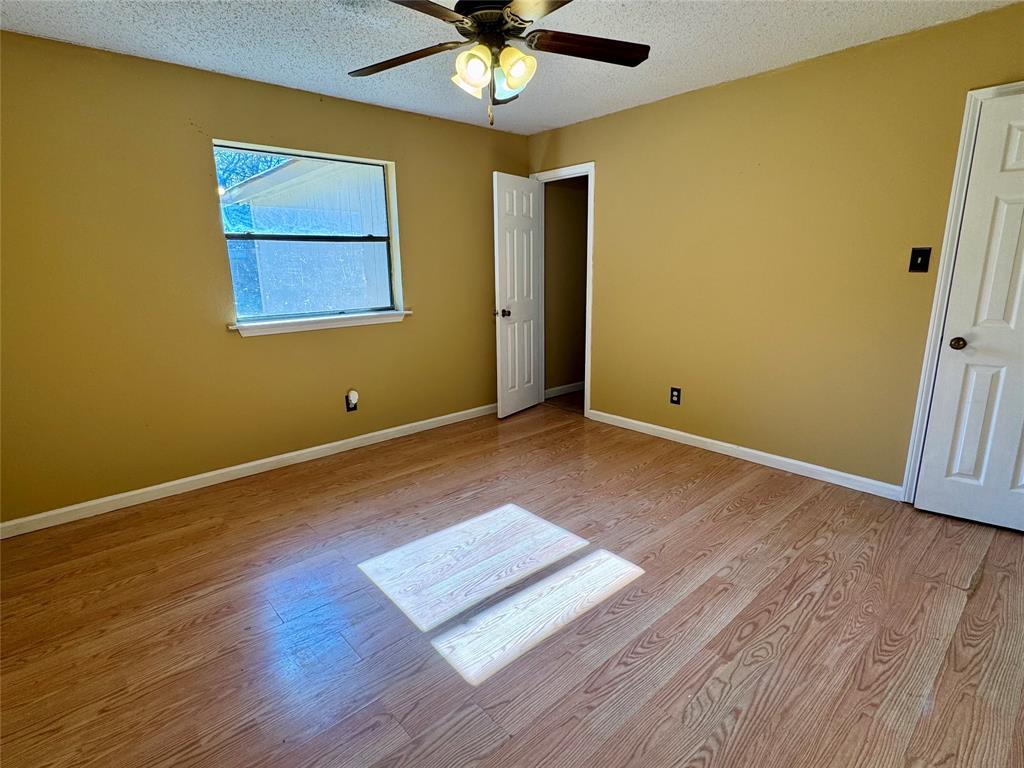 4508 Estes Park Road Haltom City, TX 76137 - Photo 11 of 17 a view of a room with wooden floor and a ceiling fan