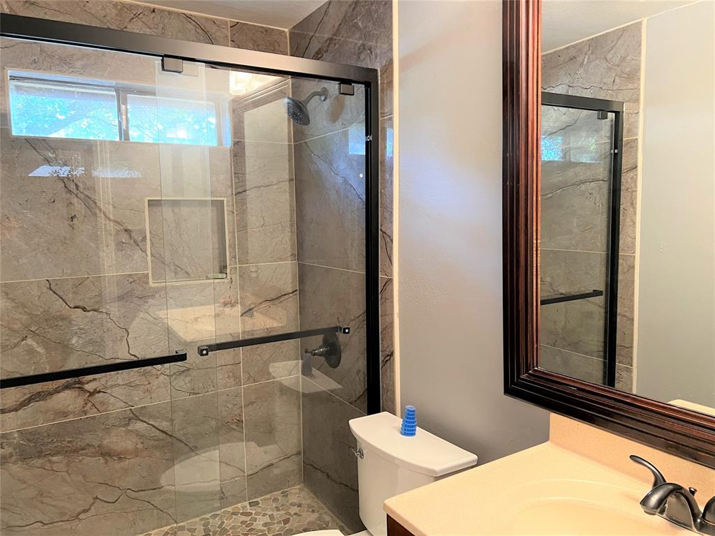 4508 Estes Park Road Haltom City, TX 76137 - Photo 12 of 17 a bathroom with a granite countertop shower and a mirror