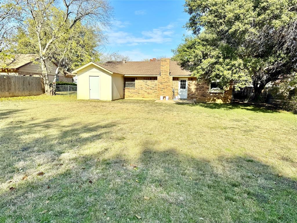 4508 Estes Park Road Haltom City, TX 76137 - Photo 17 of 17 a yellow house sitting in middle of the middle of a field
