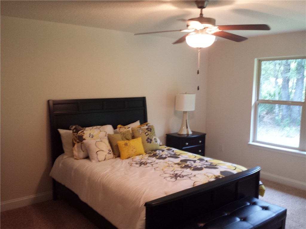 88397 Maybourne Road Yulee, FL 32097 - Photo 18 of 35 a bedroom with a bed and a chandelier