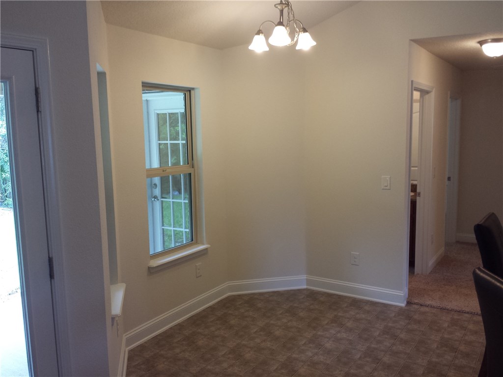 88397 Maybourne Road Yulee, FL 32097 - Photo 20 of 35 en empty room with windows and wooden floor