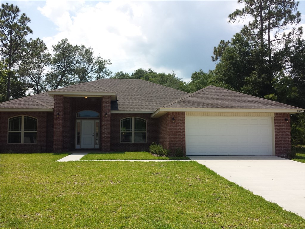 88397 Maybourne Road Yulee, FL 32097 - Photo 2 of 35 a front view of a house with a yard and garage