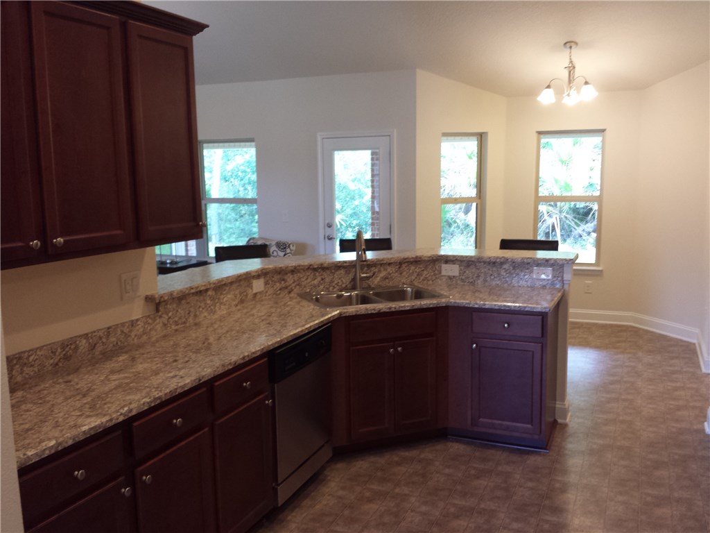 88397 Maybourne Road Yulee, FL 32097 - Photo 29 of 35 a kitchen with granite countertop a sink and a window