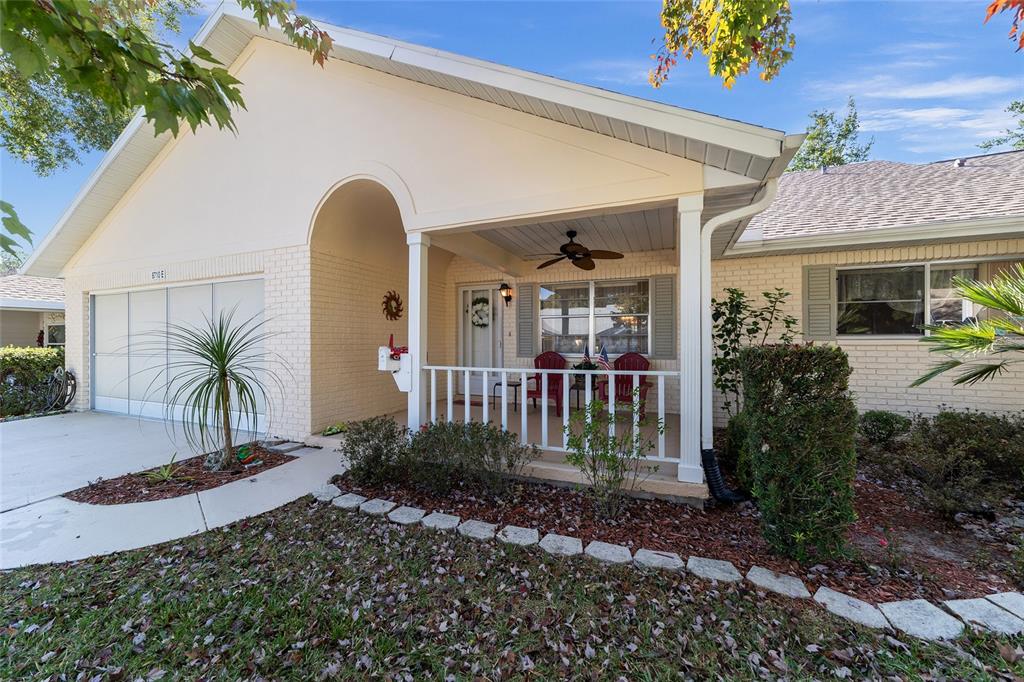 8710 Southwest 91 Street, Unit E Ocala, FL 34481 - Photo 1 of 1 a view of a house with a small yard and floor to ceiling window and potted plants