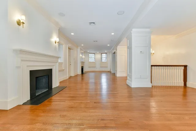 a view of a hallway with wooden floor and a fireplace
