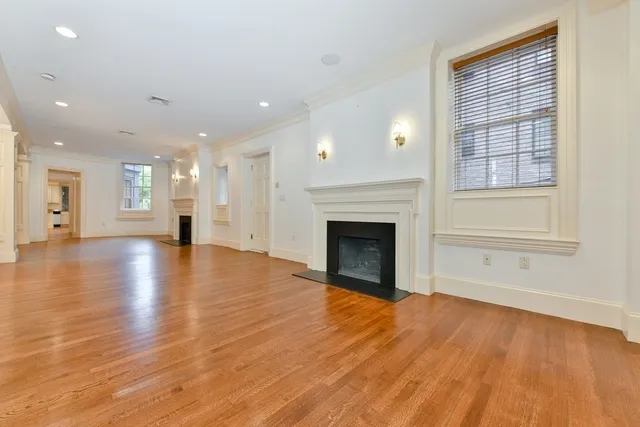 a view of empty room with wooden floor and fireplace