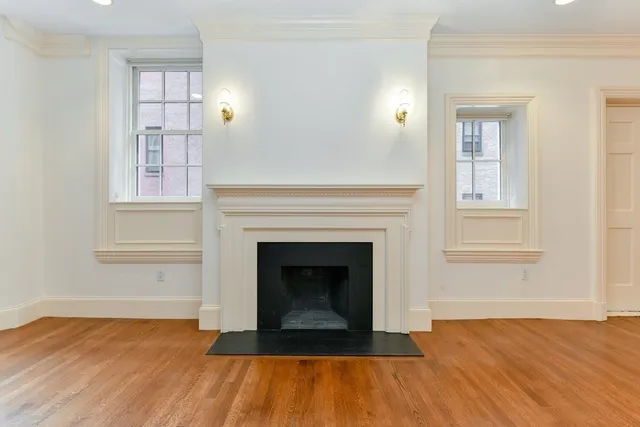 a living room with wooden floor and a fireplace