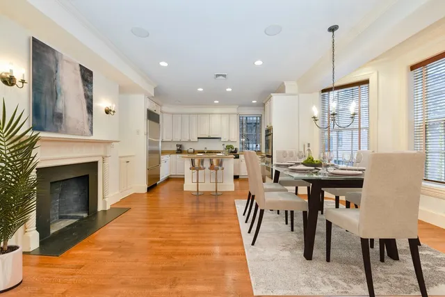 a living room with furniture a fireplace and kitchen view