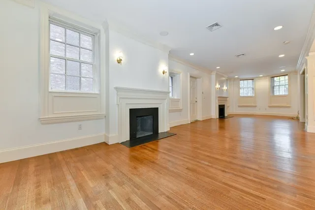 a view of empty room with wooden floor and fireplace