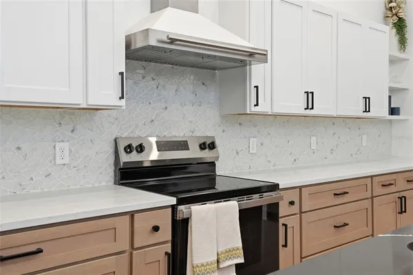 a view of an empty room with wooden floor and ceiling fan