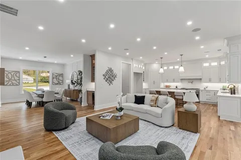a kitchen with stainless steel appliances a sink a stove a dining table and chairs