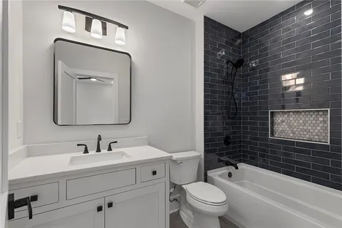 a spacious bathroom with a granite countertop double vanity sink mirror and bathtub