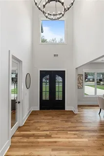 a dining room with furniture a chandelier and wooden floor