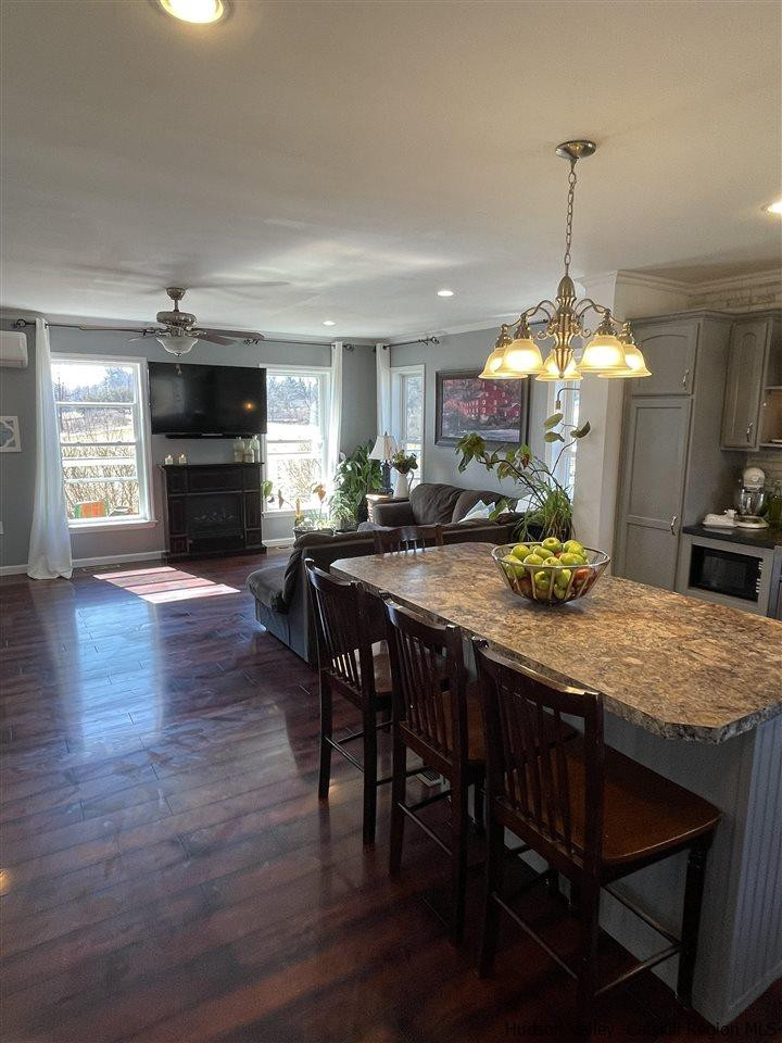 434 Cottekill Road Kingston, NY 12401 - Photo 18 of 35 a dining room with wooden floor a chandelier a wooden table and chairs