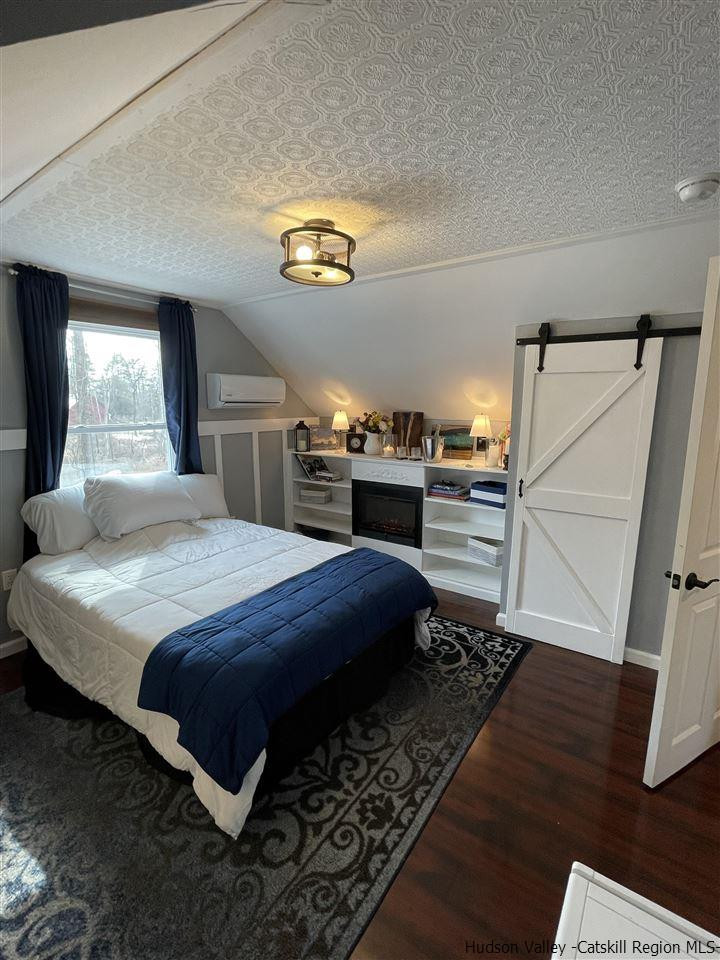 434 Cottekill Road Kingston, NY 12401 - Photo 9 of 35 a bedroom with a bed and a table with wooden floor