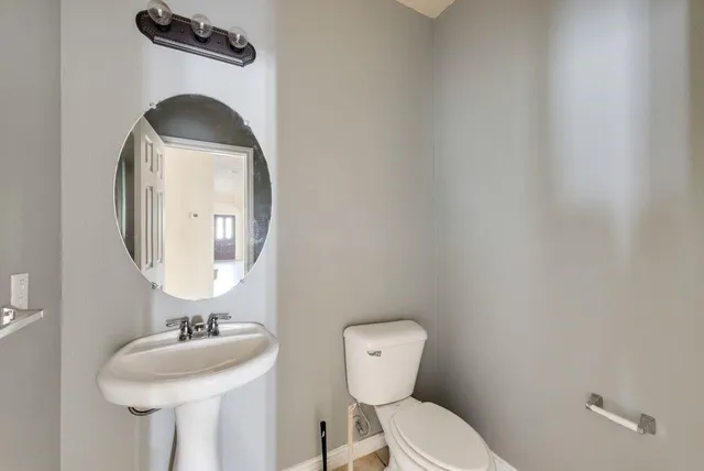 a bathroom with a toilet sink and mirror