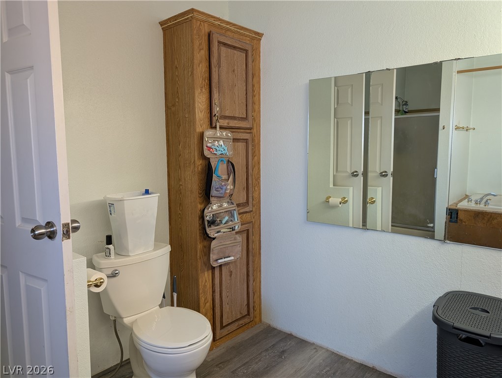 320 6th Street Panaca, NV 89042 - Photo 17 of 31 Bathroom with wood finished floors, a textured wall, and a garden tub
