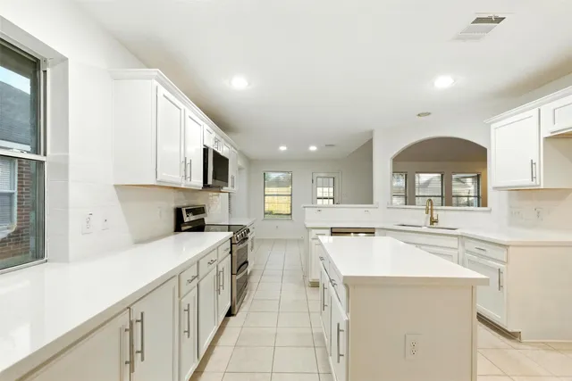 a kitchen with a sink stove top oven and cabinets