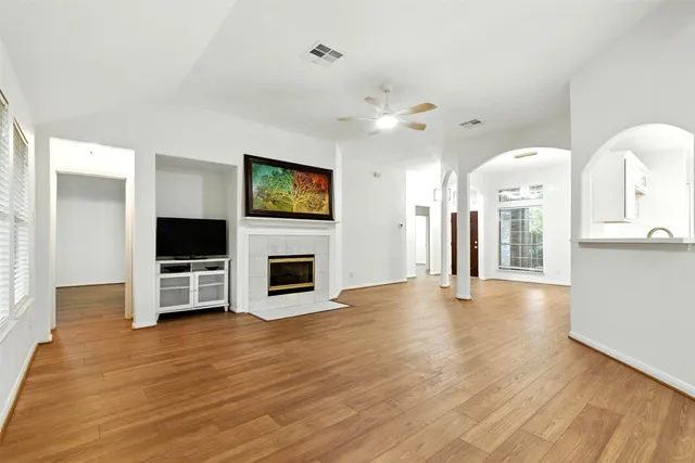 a view of a livingroom with a flat screen tv wooden floor and a fireplace