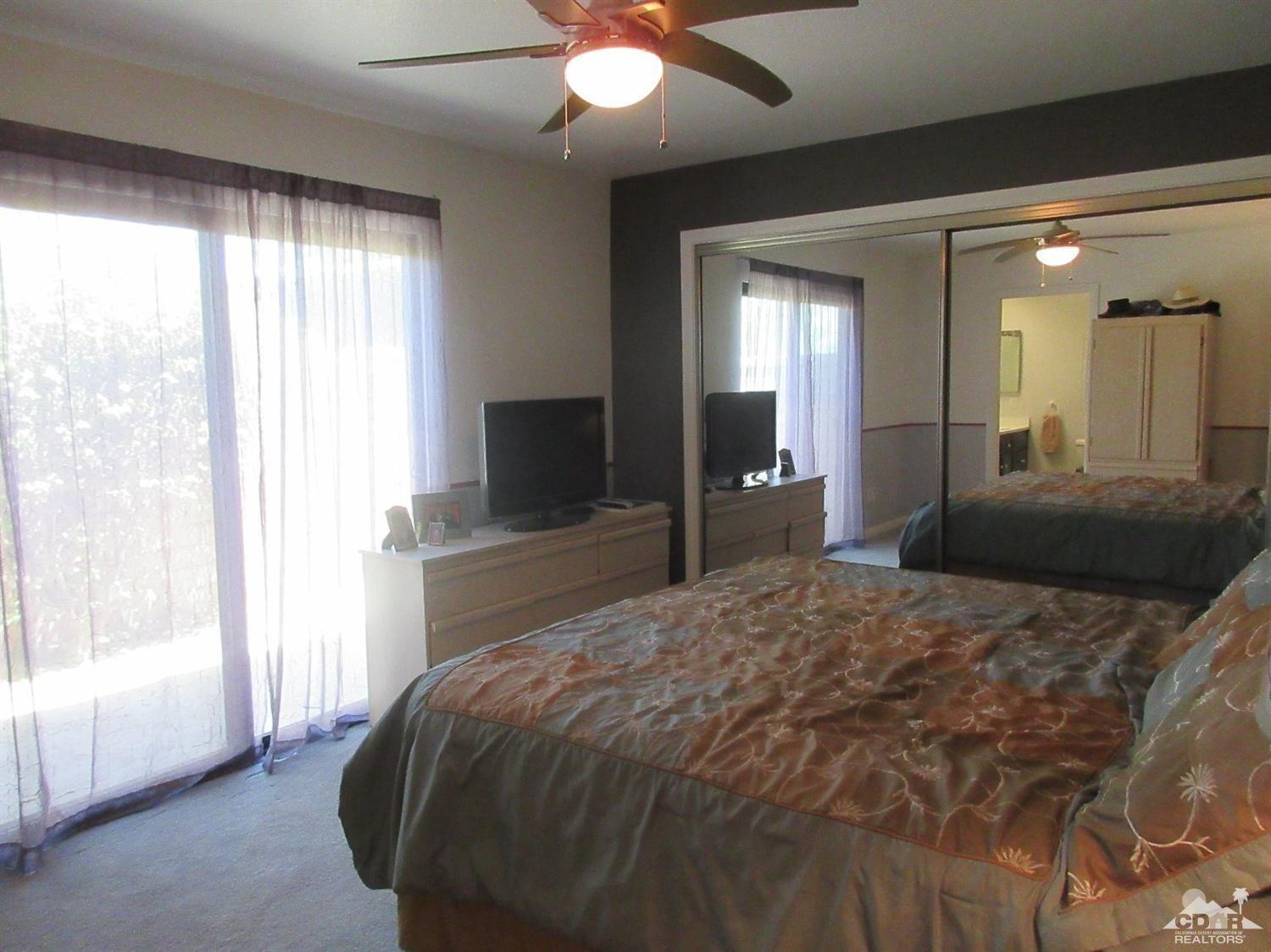 36915 Palmdale Road Rancho Mirage, CA 92270 - Photo 14 of 23 a bedroom with a large bed and a flat tv screen on dresser