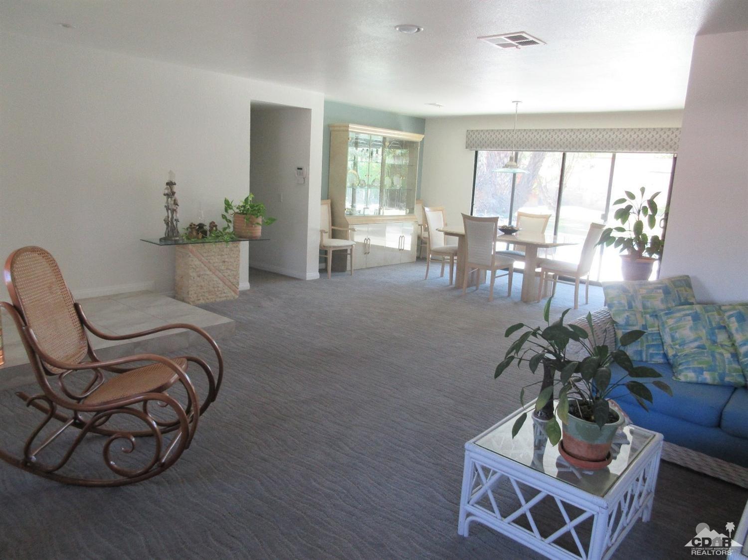 36915 Palmdale Road Rancho Mirage, CA 92270 - Photo 5 of 23 a living room with furniture a large window and potted plants
