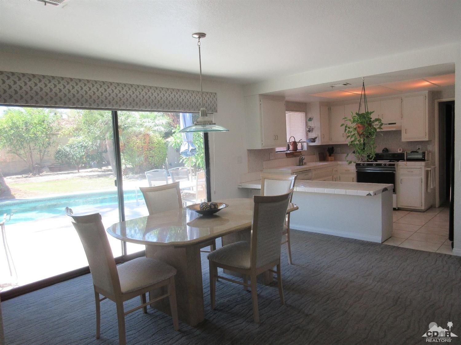 36915 Palmdale Road Rancho Mirage, CA 92270 - Photo 8 of 23 a dining room with furniture a chandelier and wooden floor